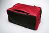 Red Sleepypod Atom Airline Approved Pet Carrier shown unzipped for attaching to a telescoping luggage handle.