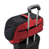 Sleepypod Air shown in red affixed to telescoping luggage handle