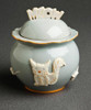 Cat treat jar exterior features include raised motifs such as a cat, fish bone, ball of yarn and a mouse