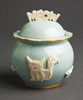 Meow lid topper and cat decorations contrast with the baby blue glaze