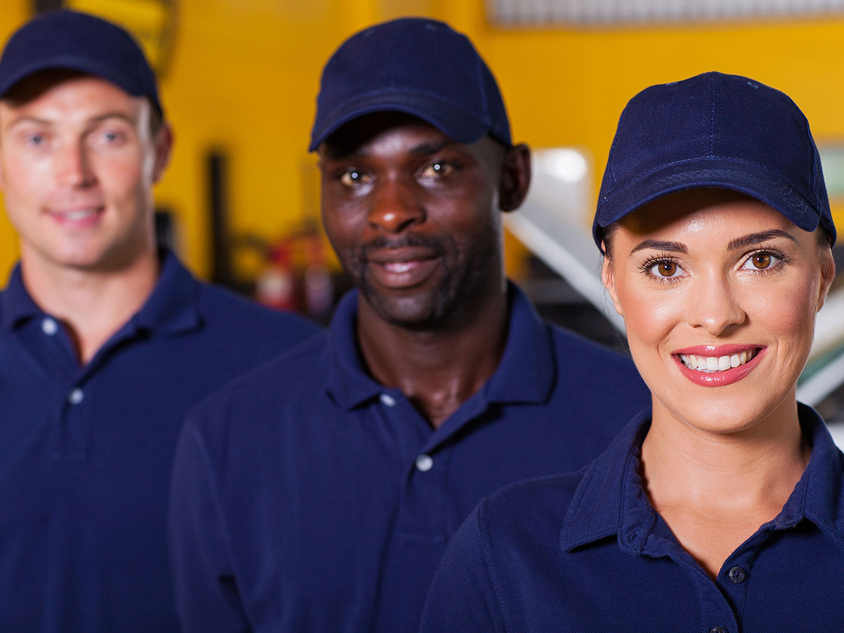 Three smiling auto repair technicians. 