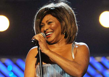 Tina Turner on stage holding microphone laughing in silver dress 5x7 inch photo