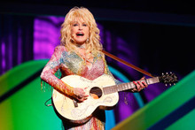 Dolly Parton plays her guitar in colorful sequined dress 12x18 poster