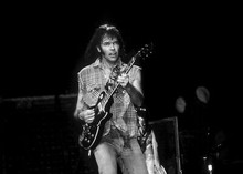 Neil Young plays guitar in concert 5x7 inch press photograph