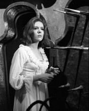 Diana Rigg wearing nightdress & robe looks at spears on wall Avengers 8x10 photo