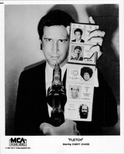 Chevy Chase holding ID's 8x10 photo as Fletch