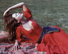 Claudia Cardinale in low cut red dress lying on grass 8x10 inch photo
