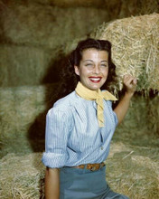 Gail Russell smiling portrait in blue shirt sits on bale of hay 8x10 inch photo