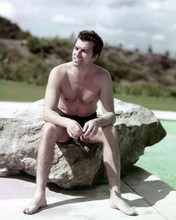 Fernando Lamas in swim trunks smiling as she sits on rock 1950's 8x10 inch photo