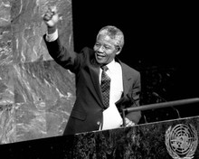 Nelson Mandela smiles as he gestures with his hand in the air 8x10 inch photo