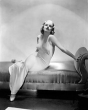 jean Harlow wears sheer cut white gown sitting on sofa 8x10 inch photo