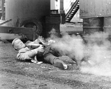 John Wayne firing gun lying on ground 1975 Brannigan 8x10 inch photo