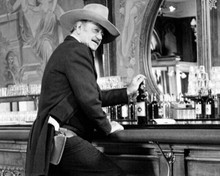 The Shootist 1976 John Wayne grabs bottle of whiskey on saloon bar 8x10 photo