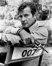 Roger Moore on Live and Let Die set in 007 chair holding gun 8x10 inch photo