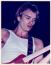 Sting of Police in white sleeveless top playing guitar in concert 8x10 photo