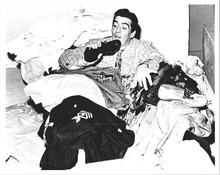 Victor Mature lying in pile of clothes holding a shoe 8x10 inch photo