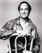 Neil Sedaka sits on chair in open zip jacket 1980's era 8x10 inch photo