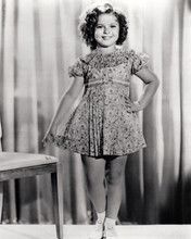 Shirley Temple hand on hip smiling standing by chair 8x10 inch photo