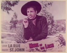 Mark of the Lash "Lash" La Rue sits on fence in black outfit vintage 8x10 photo