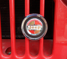 Grill emblem, Reproduction grill emblem. Found on Kaiser era jeeps. Metal casting, chrome plated, raised letters, polished, painted to original colors.  Comes complete with mounting br...

