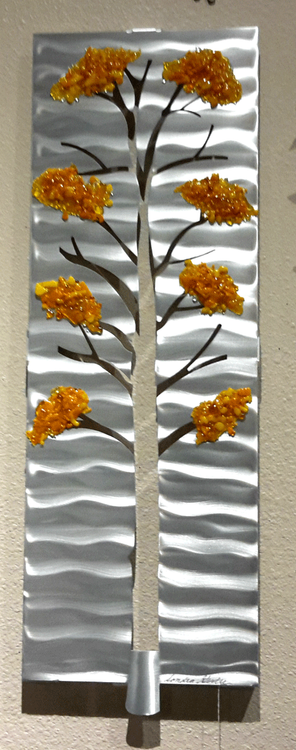 Four Seasons - Fall, 10"x27" by Sondra Gerber
Hand brush aluminum and fused glass wall sculpture.  The use of positive and negative shapes within the intricate cut of the designs cast alluring shadows that interact with the piece itself.