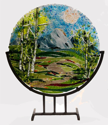 The 'Spring Ribbons'  in a steel stand by Kathi Dougherty captures the spring colors of a lovely mountain day. This 16" fused glass round rests in a black coated steel stand for displaying.

Shop now or call to speak with a sales associate for additional assistance.  
Earthwood Collections, 970-577-8100