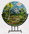 The 'Spring Ribbons'  in a steel stand by Kathi Dougherty captures the spring colors of a lovely mountain day. This 16" fused glass round rests in a black coated steel stand for displaying.

Shop now or call to speak with a sales associate for additional assistance.  
Earthwood Collections, 970-577-8100