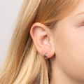Girl wearing silver star hoop earrings