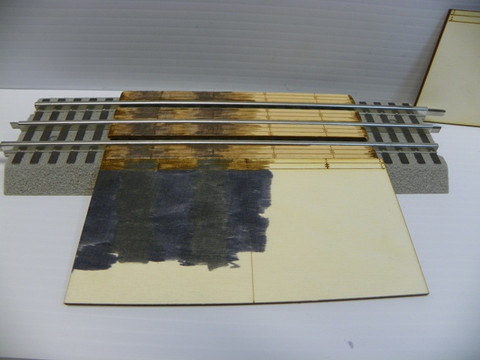 Grade crossing with one (side) ramp added and staining of one lane of crossing and painting of one lane of ramp started.