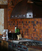 4x4 copper tiles in fired patina on inside kitchen wall.