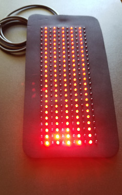 Red LED light therapy pad for pain relief and inflammation, showing flexible design specifically for treating large areas.