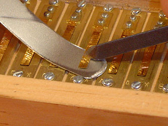 Scraping a small amount of metal from a harmonium reed