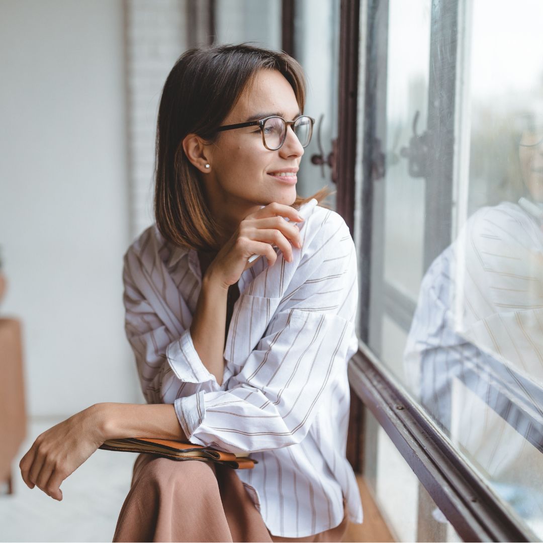 person smiling looking out of window