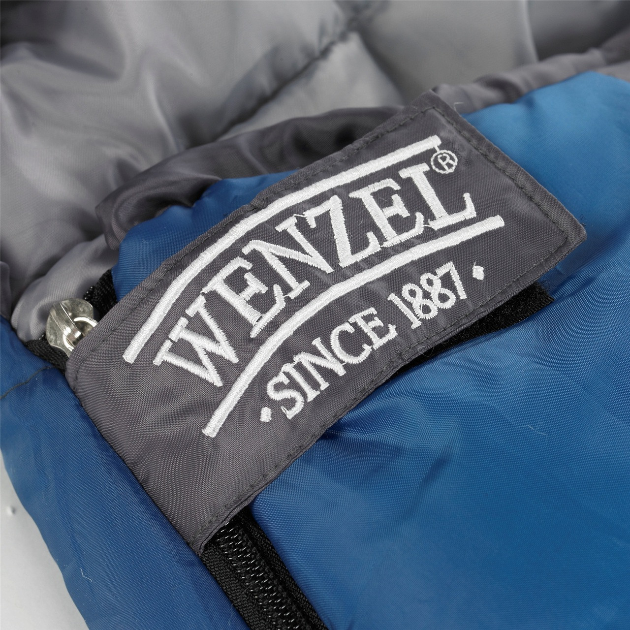 Close up view of the Velcro zipper latch over the zipped showing 'Wenzel since 1887' text