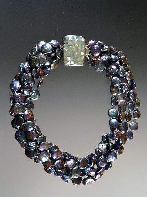 This multi-strand dark peacock coin pearl torsade features a rare Amina pearl clasp that can be worn as a side or center highlight as you wish.  20"
