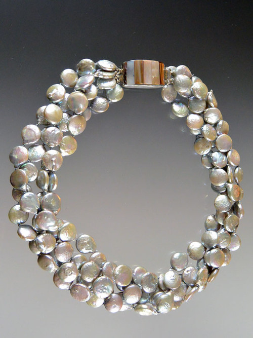 This luminous silver silk hand-knotted coin pearl torsade fatures a one-of-a-kind inlaid multi-toned shell clasp that can be worn as a side or center highlight.  20"