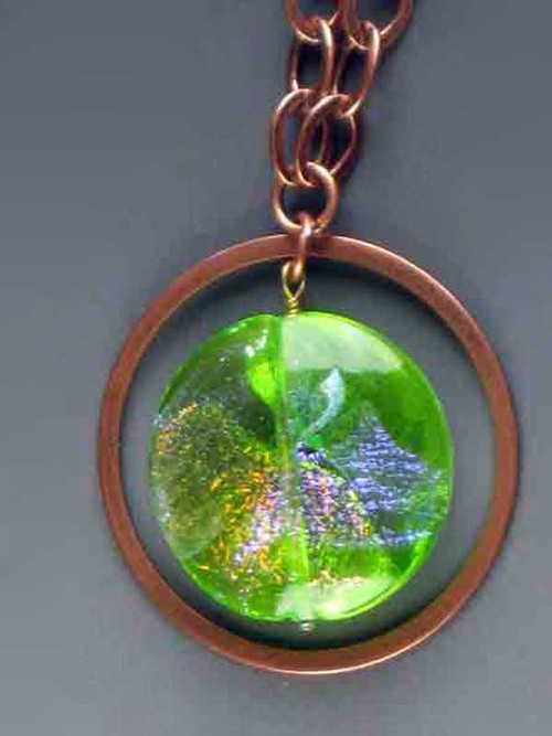 Make a dramatic statement with this dichroic* Venetian glass disc pendant with sparks of verdant green, aqua and gold) suspended from a copper ultraplate hoop (2") and looped chain 30"  Each specimen different and equally fascinating. 