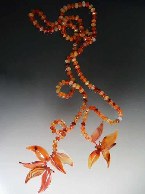 Another fun colorful layering piece, this lariat features multi-toned faceted carnelian rondels hand knotted with red silk and ending with hand-carved carnelian leaves.  Your imagination can wear this many ways -- just knotted, doubled like a scarf with the ends pulled through or wrapped around your neck.  Note: the carved leaves are delicate so don't bang them against hard surfaces. 48"  ONLY THREE!