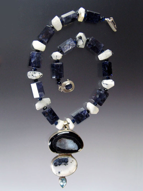 An absolute one of a kind showstopper!  This magnificent piece features step cut iolite (of the sapphire family spaced with white opal and snow leopard with a large gorgeous blue agate snow leopard, blue topaz pendant.  20" Pendant 3"