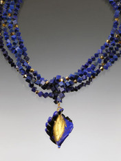 Luxuriate in six strands of Grade AAA lapis dice spaced with 24K Swarovski crystals.  A dramatic Venetian glass swirl centerpiece creates an elegant torsade look. 