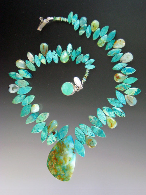 As they say in French this is a "piece de resistance!" Several years ago I found 2 amazing Brazilian peruvian opal pendants -- each a unique artwork with a landscape of pale aqua, deep greens, flashes of copper.  Each is the centerpiece of an equally stunning necklace composed of alternating marquis cut grade AAA chrysocolla and peruvian opal beads. This is very special. Necklace 18" pendant 2" x 1.5"