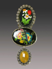 This charming Amy Kahn Russell pin/pendant evokes bygone eras.  It features a brilliantly hand embroidered floral oval top, a large colorful enameled oval center and a yellow opal dangle all set in an intricately patterned sterling frame with a brass backing  Perfect for right now and all year. 4-1/2" x 2"