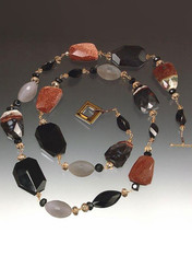 A striking collage of shapes and colors! Faceted multi-agate slices artfully mixed with grey and black onyx, cognac Swarovski crystals, raw garnet, hand-wire non-tarnish gold/copper wire. Wear alone or pair with others in the collection. 34"