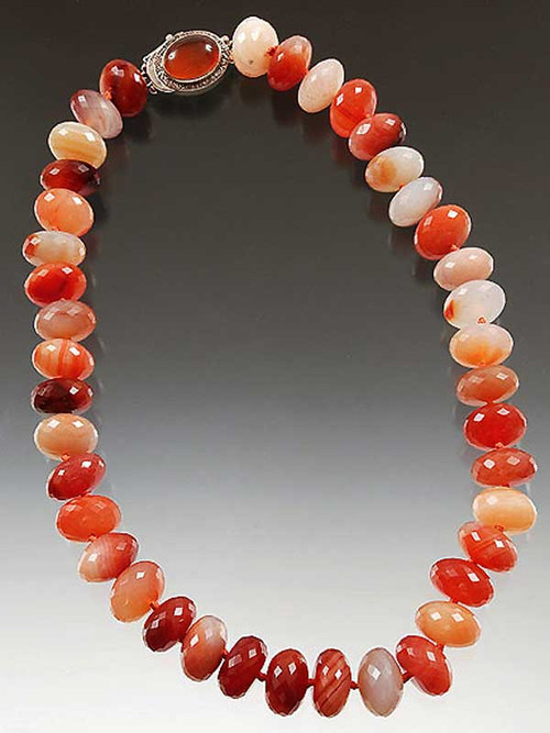Brighten your day with a sparkling 18" collar of faceted grade AA carnelian flashing every tone from amber to deep orange. Japanese double hand-knotted with  red silk. A highlight 1"  carnelian sterling clasp can be worn side, center or back.  