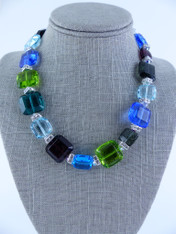 This cheerful collar of jewel-toned puffed Venetian glass in large and small square shaped spaced with discontinued Swarovski crystal "squaredells" and iridescent Swarovski crystals is perfect for any occasion and blends with many colors. Translucent and opaque blend beautifully. No two identical and very limited.  Perfect for the holidays. 18"