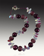 This striking collar by Yumiko Togashi features a collage of wine shiny and matte Venetian glass beads paired with delicate hand carved glass iridescent leaves and a vintage wine and silver clasp.  Light and elegant for any occasion. 18"