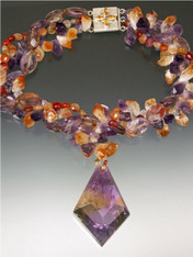 A spectacular 2" x 2" faceted ametrine pendant falls from a raw amethyst, citrine and carnelian 20" torsade.  ONE OF A KIND