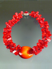 If you want to make a WOW dramatic statement, this dazzling creation is for you.  Huge tomato red coral florets frame a one of a kind 2-1/2" glazed Venetian Glass Disc (snagged at a trade show many years ago waiting for the right opportunity and setting) with a sunburst pattern of deep red, orange and gold . A red coral sterling 1" custom clasp completes the design. Picture this on bright white, black, or the new bold tones of the season. Total length 22"  