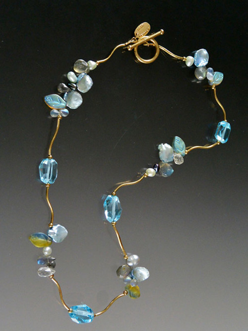 Brazil boasts the world's finest topaz and this blue beauty is no exception. Brilliantly faceted gemstones and precious clusters of freshwater pearls, petal pearls, labradorite, and frosted hand-carved glass leaves nestle between14K curved branches and 14K clasp 17-1/2"