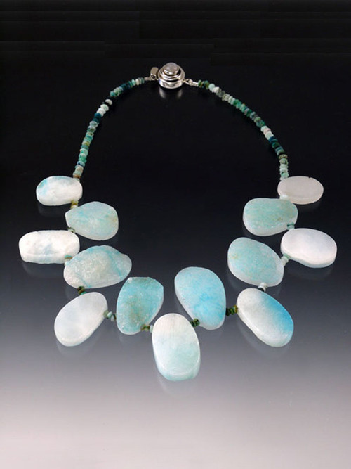  Larimar is a rare gemstone found exclusively in a remote mountainous region of Santo Domingo. This unusual collar can be worn on the "raw" side or as a flat polished collar. Multi-toned Peruvian Opal rondels and a custom moonstone clasp complete the piece   21"  